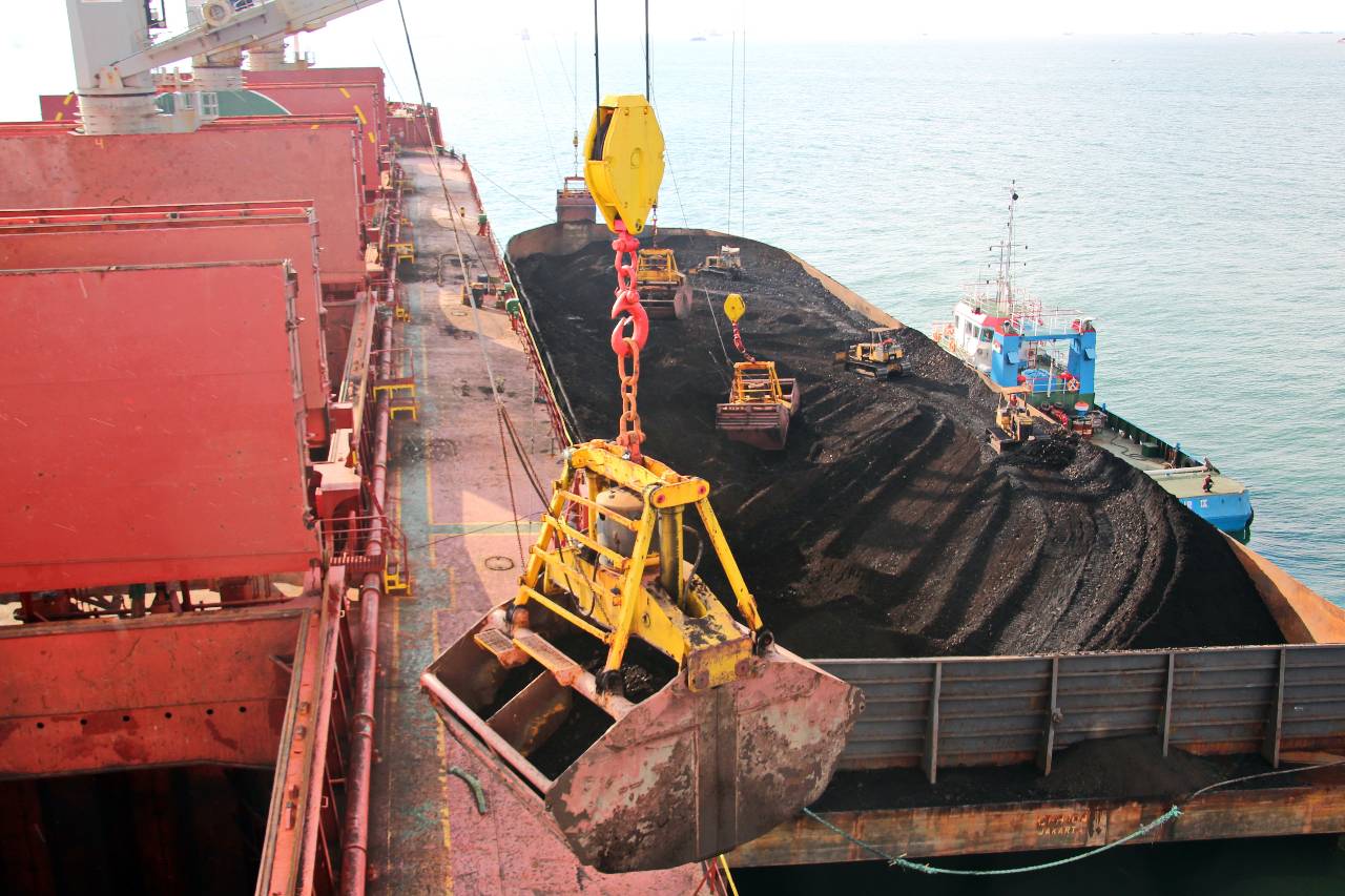 Ivan Kuzkin Loading coal from cargo barges onto a bulk carrier using ship cranes and grabs at the port of Samarinda, Indonesia.